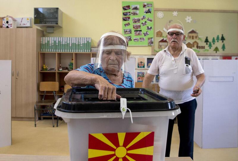 An couple wearing face shields cast their vote in the general election in Skopje, North Macedonia on July 15. AFP
