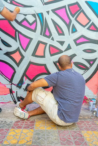 Artist eL Seed working on a mural inside the Ain Al Hilweh camp. Courtesy 81 Designs