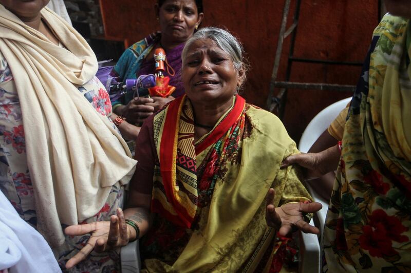 A woman who lost her family members cries as rescue workers search for survivors after a wall collapsed on shanties due to heavy rains at a slum in Mumbai. Reuters