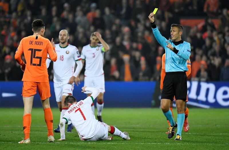 Netherlands' Marten de Roon is shown a yellow card by referee Davide Massa. Reuters