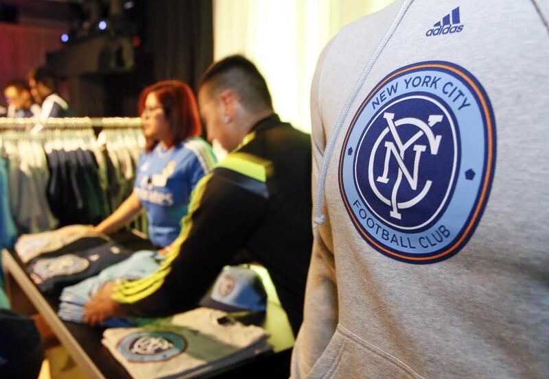 Sales people arrange team merchandise as they begin sales after the new MLS franchise New York City Football Club unveiled their new team badge in New York. New York City Football Club / Ray Stubblebine / AP Photo