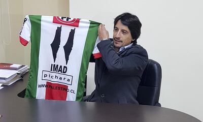 Roberto Kettlun, sports manager for Deportivo Palestino, holds up a football shirt with the map of Palestine replacing the 1's. Juman Jarallah / The National 