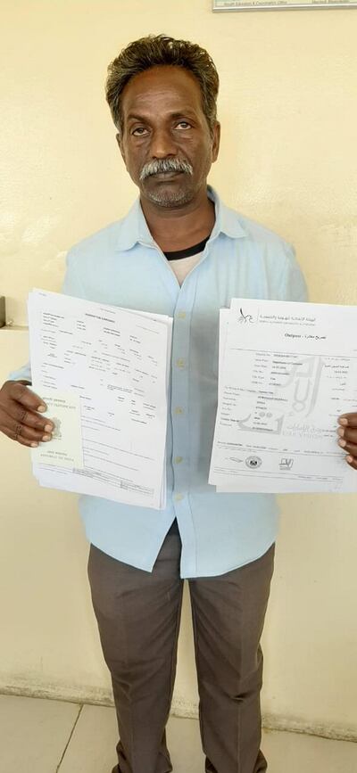 Durgaiah Dobbali, a construction worker, shows the official papers that allowed him to return to his family in India. Girish Pant