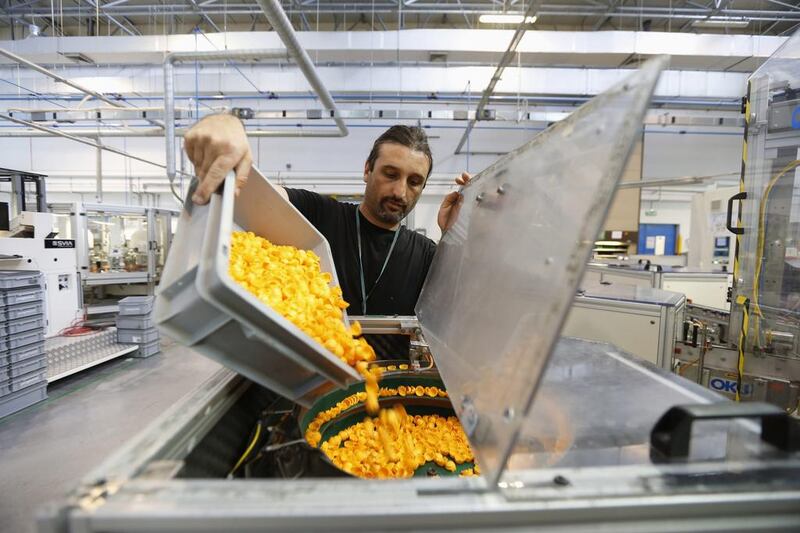 An employee pours Playmobil figure hair pieces into an assembly machine at the Playmobil Malta factory. Darrin Zammit / Reuters