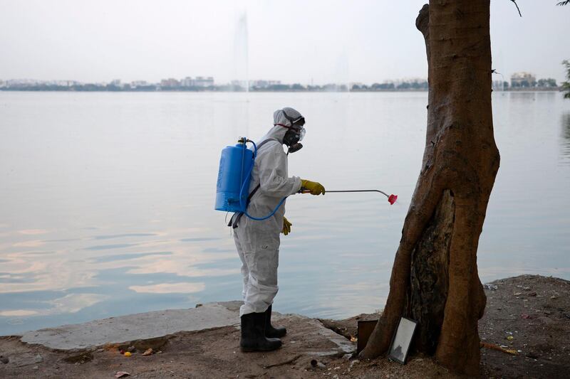 A member from Disaster Response Force (DRF) of Telangana State, wearing a protective gear sprays disinfectant on a public place amid concerns over the spread of the COVID-19 novel coronavirus, in Hyderabad.  AFP