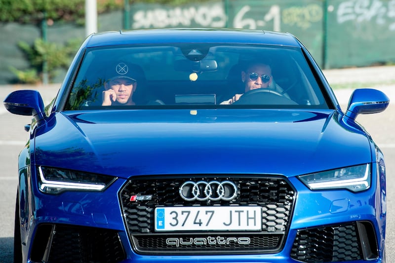 Barcelona's Brazilian forward Neymar (R) drives into the parkinglot to take part in a training session at the Sports Center FC Barcelona Joan Gamper in Sant Joan Despi, near Barcelona on August 2, 2017 following rumour that he is considering a move to French club PSG for which the club would have to shell out some 222 million euros, enough to trigger the 25-year-old's transfer release clause. / AFP PHOTO / Josep LAGO