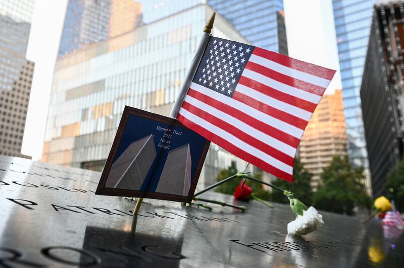 An American flag placed along with a photo of the Twin Towers and the name Daniel P.  Trant, a Cantor Fitzgerald bond trader that died during 9/11, before ceremonies to commemorate the 20th anniversary of the Sept.  11 terrorist attacks at the National September 11 Memorial & Museum in New York.   AP