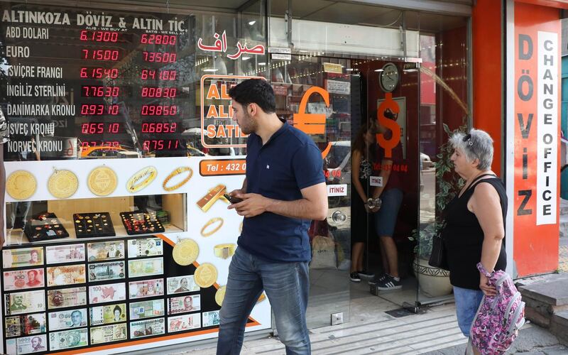 People look at foreign exchange rates in Ankara, Turkey, on August 28, 2018. (Photo by ADEM ALTAN / AFP)