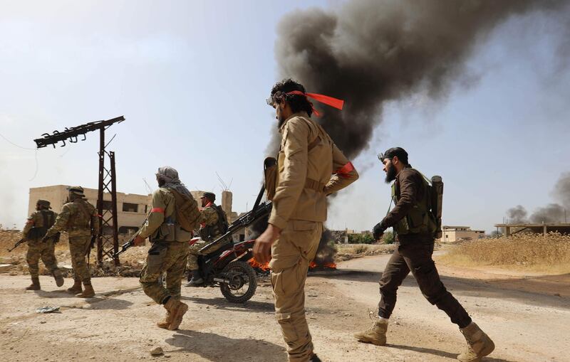 Fighters with the Turkish-backed National Liberation Front hold a position in Syria's Hama province. AFP