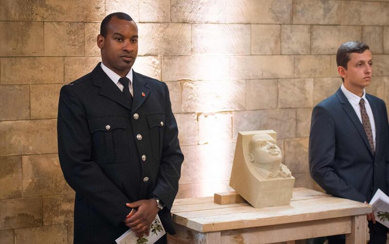 British Transport Police officer Wayne Marques, who was seriously injured fighting off the attackers, stands next to a corbel of his face which will be placed on the north quire aisle of Southwark Cathedral. AFP/POOL/Dominic Lipinski