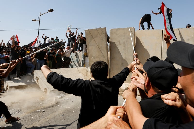 Supporters of Iraqi Shiite cleric Moqtada Al Sadr pull down a concrete barrier during a protest against corruption in Baghdad on July 30. Reuters