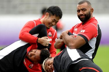 Japan captain Michael Leitch, top right, stretches team-mate Lomano Lava Lemeki during a training session ahead of their World Cup quarter-final against South Africa on Sunday. AP