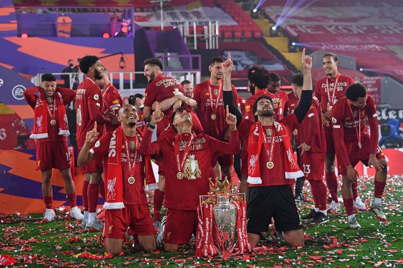 Fabinho, left, goalkeeper Alisson, right, and Roberto Firmino, all from Brazil, celebrate with the Premier League trophy. AP