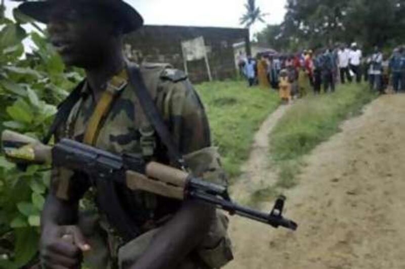 **  FILE  ** In this Monday, Aug. 14, 2006, file photo local villagers watch a Nigerian soldier walk by in Archibong in the southern Bakassi Peninsula, as Nigerian troops withdrew from the disputed area which was officially handed over to Cameroon. A Cameroon militia group took 10 mostly foreign oil workers hostage from a tug the Bourbon Sagitta, operated by the French maritime services company Bourbon, Friday, Oct. 31, 2008 off the West African nation's coast, and threatened to kill the captives if demands for autonomy talks with the government are not met. (AP Photo/George Osodi, File) *** Local Caption ***  LON101_Nigeria_Piracy_Cameroon.jpg