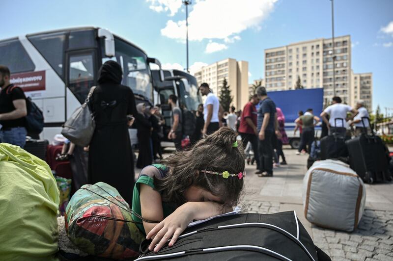 A Syrian girl weeps as other voluntary Syrians prepare to board buses to return to neighbouring Syria on August 6, 2019 in the Esenyurt district of Istanbul.  The Esenyurt municipality of western Istanbul supports Syrian refugees willing to go back voluntarily to syria , providing a bus service to repatriate them home. / AFP / Ozan KOSE
