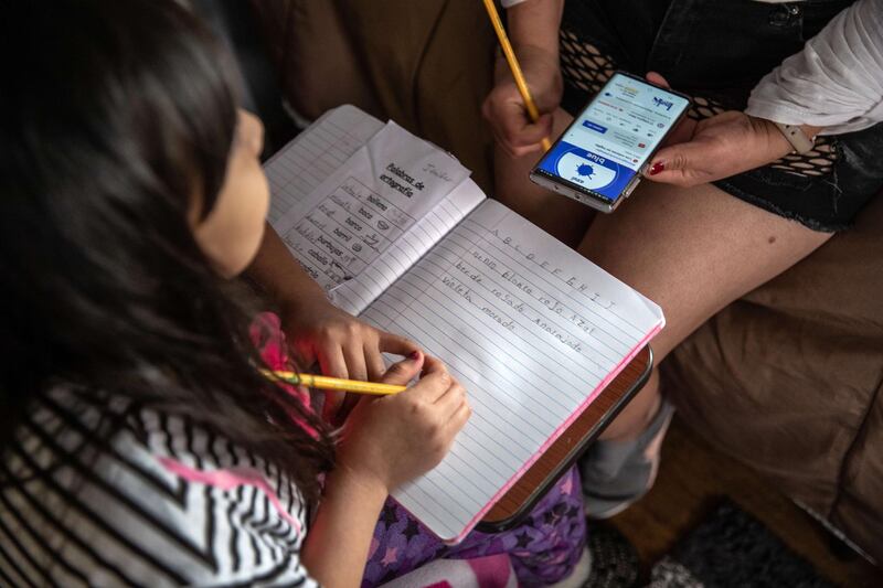 A mother and daughter, 8, from Honduras, study English on March 30, 2020 in Mineola, New York. Getty Images / AFP