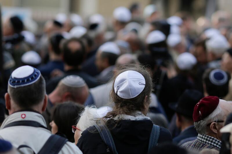 FILE - In this Wednesday, April 25, 2018 file photo people wear Jewish skullcaps, or kippa, as they attend a demonstration against an anti-Semitic attack in Berlin, Germany. A new survey says about one in four Europeans hold anti-Semitic beliefs, with such attitudes on the rise in eastern countries and mostly steady in the west.  (AP Photo/Markus Schreiber, file)