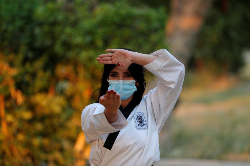 Enas Atta wears a protective face mask while training taekwondo in Abu Nawas park, following the outbreak of Covid-19, in Baghdad, Iraq. Reuters