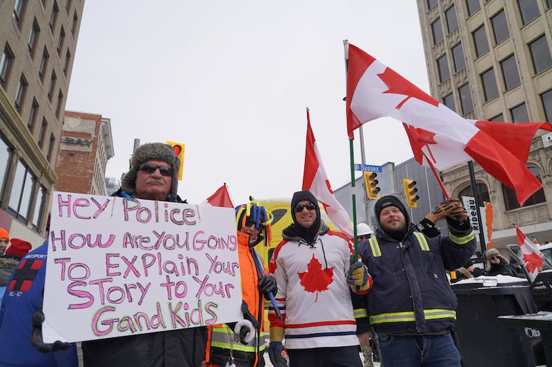 Three men pose for a picture while attending the anti-vaccine protests in Ottawa. Willy Lowry / The National.