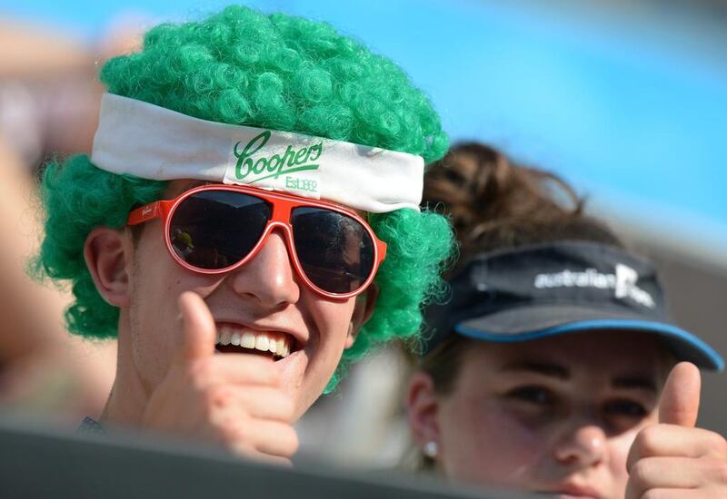 A fan in a green wig flashes the thumbs-up sign at the Australian Open on Wednesday.