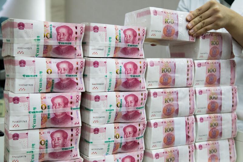 An employee arranges genuine bundles of Chinese one-hundred yuan banknotes at the Counterfeit Notes Response Center of KEB Hana Bank in Seoul, South Korea, on Monday, Aug. 14, 2017. China's factory output and investment slowed somewhat in July, according to data released today, yet the yuan appeared not to take the data as negative, if in fact it's paying attention to it at all. Photographer: SeongJoon Cho/Bloomberg