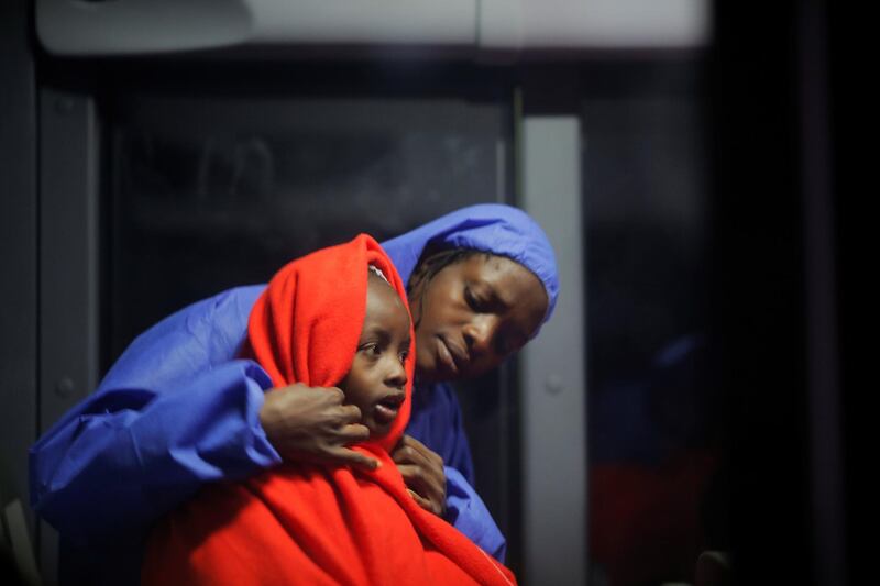 A migrant woman and a child, intercepted off the coast in the Mediterranean Sea, sit in a bus after arriving on a rescue boat at the port of Malaga, southern Spain. Reuters