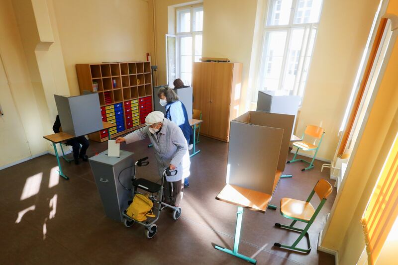 A person casts their vote as Olaf Scholz, the Social Democratic Party candidate for chancellor, sits at a polling booth to vote in the general election, in Potsdam. Reuters