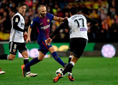 Barcelona's Spanish midfielder Andres Iniesta (L) vies with Valencia's French midfielder Francis Coquelin during the Spanish 'Copa del Rey' (King's cup) second leg semi-final football match between Valencia CF and FC Barcelona at the Mestalla stadium in Valencia on February 8, 2018. / AFP PHOTO / JOSE JORDAN