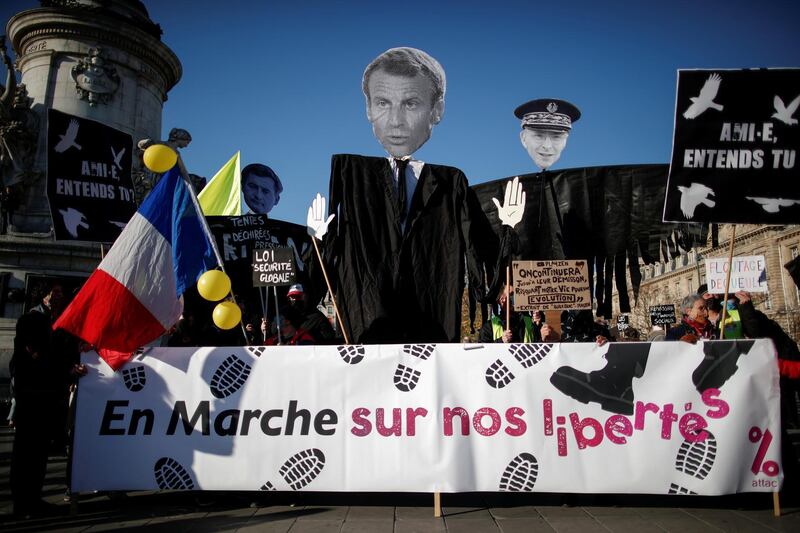 FILE PHOTO: People attend a demonstration against the "Global Security Bill' that rights groups say would make it a crime to circulate an image of a police officer's face and would infringe journalists' freedom in France, at the Place de la Republique in Paris, November 28, 2020. Banner reads: "En Marche on our freedoms". REUTERS/Benoit Tessier/File Photo