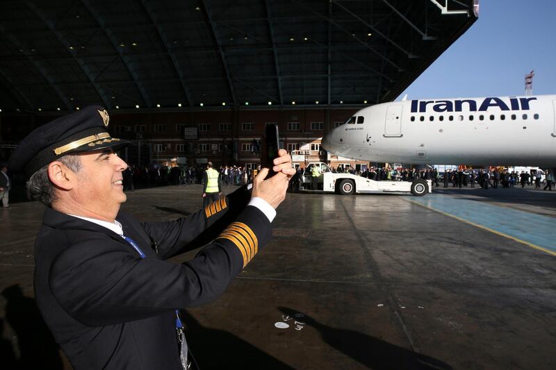 FILE - In this file photo taken on Jan.12, 2017, Iran Air pilot Mehdi Jafarzadeh takes a picture of the arrival of his company's new Airbus plane at Mehrabad airport, in Tehran, Iran. European governments are scrambling for ways to save billions of dollars in trade that could collapse because of U.S. President Donald Trump's decision this week to re-impose sanctions (AP Photo/Vahid Salemi)