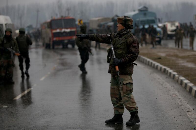 An Indian paramilitary soldiers gestures as he stands guard near the site of an explosion in Pampore, Indian-controlled Kashmir. Security officials say at least 10 soldiers have been killed and 20 others wounded by a large explosion that struck a paramilitary convoy on a key highway on the outskirts of the disputed region's main city of Srinagar. AP Photo