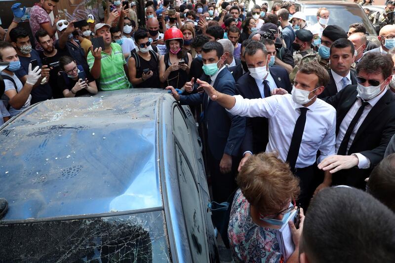 French President Emmanuel Macron visits the Gemayzeh neighborhood, which suffered extensive damage from an explosion on Tuesday that hit the seaport of Beirut. AP Photo