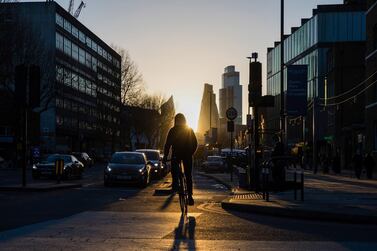 A cyclist on the Mile End Road against a backdrop of skyscrapers in the City of London. An expected rebound in the economy will follow a 2.3 per cent quarter-on-quarter fall in GDP in the first three months of 2021. Bloomberg