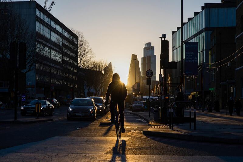 A cyclist on the Mile End Road against a backdrop of skyscrapers in the City of London square mile financial district in London, U.K., on Thursday, Feb. 18, 2021. Amsterdam overtook London as Europe's largest share trading center in January after Brexit saw about half of the city's volumes move to the continent. Photographer: Chris Ratcliffe/Bloomberg
