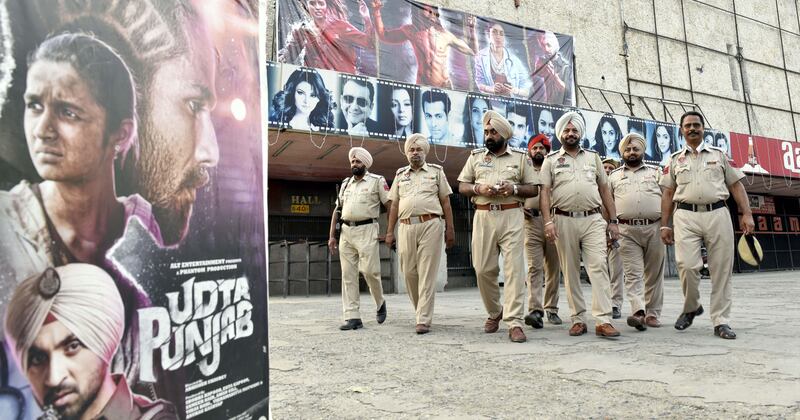 AMRITSAR, INDIA - JUNE 17: Police personnel deployed on duty outside the cinema hall after release of movie Udta Punjab at Aanaam Cinema hall, as various Hindu organizations protest against Film Udta Punjab, the drug-themed Bollywood film that was embroiled in a censorship row and multiple legal battles, on June 17, 2016 in Amritsar, India. The protestors carried placards and raised slogans against the producers and director. (Photo by Gurpreet Singhl/Hindustan Times via Getty Images)