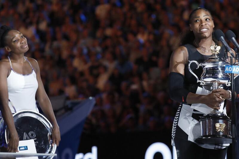 Serena Williams gives her winner’s speech as Venus looks on. Kin Cheung / AP Photo