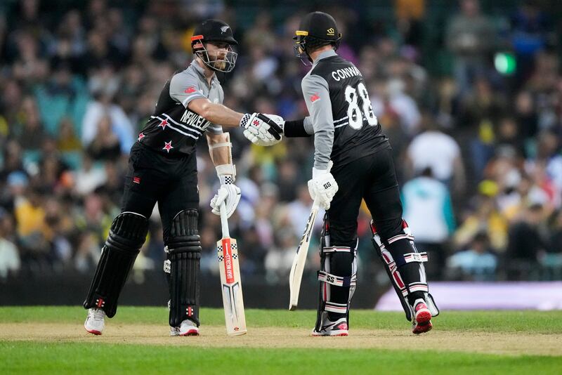 New Zealand captain Kane Williamson, left, congratulates teammate Devon Conway after he reached 50 runs. AP