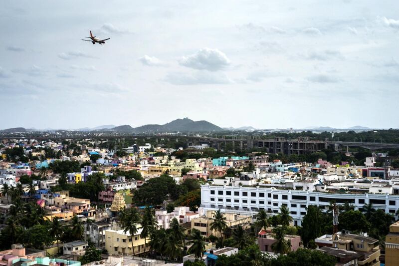 A commercial airliner flies over the city in Chennai, Tamil Nadu, India, on Monday, July 21, 2014. Optimism about a revival in Asias third-largest economy is rising after the landslide election victory in May of Prime Minister Narendra Modi, who has pledged to accelerate investment in the nations highways, power plants, ports and housing. Photographer: Sanjit Das/Bloomberg via Getty Images