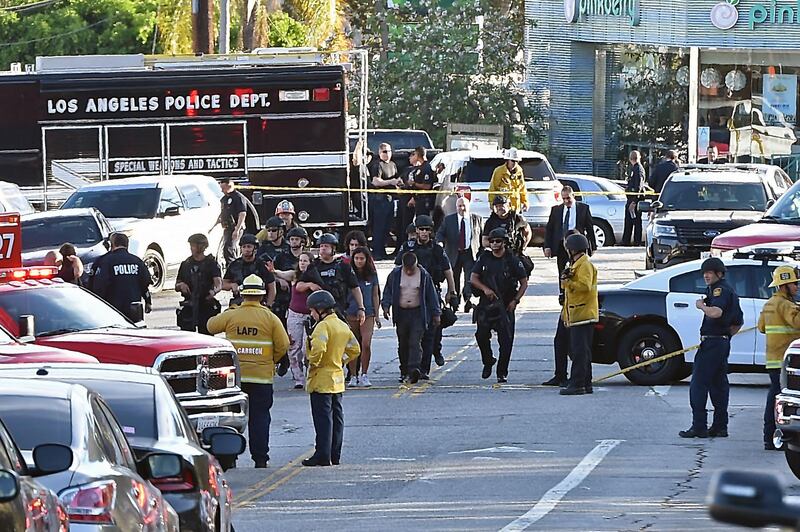 Police officers escort people after a suspect barricaded inside a Trader Joe's supermarket in Silverlake, Los Angeles, on July 21, 2018. A suspect wanted in connection with a shooting was barricaded inside a supermarket in the US city of Los Angeles on Saturday, police said, in what US media reported was a possible hostage situation. / AFP / Robyn Beck
