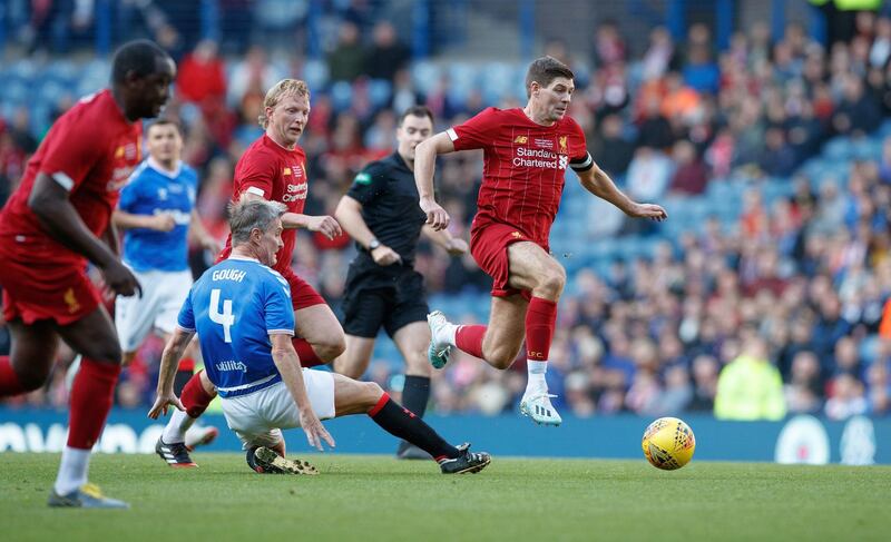 Liverpool great Steven Gerrard jumps clear of Rangers' Richard Gough during the legends match at the Ibrox Stadium in Glasgow. Press Association