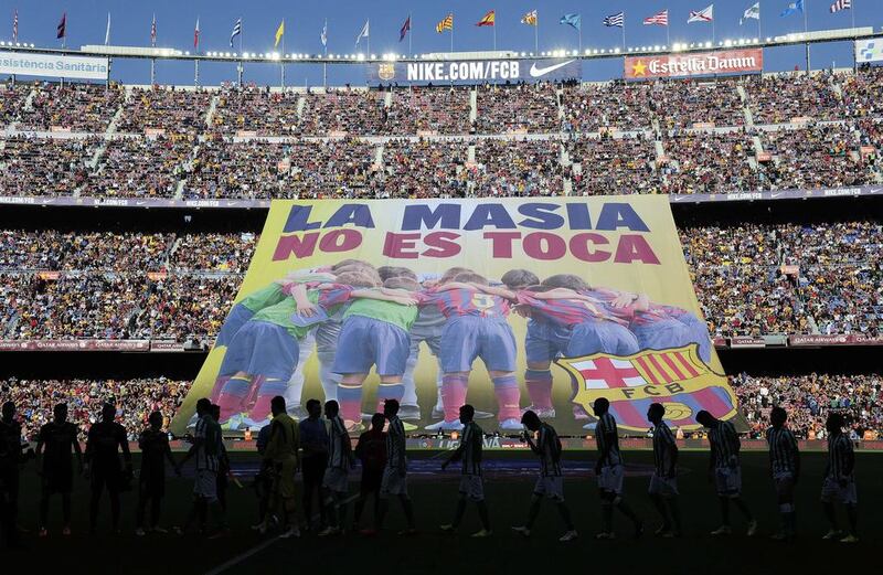 Barcelona's supporters unveil a giant banner reading in Catalan "La Masia, don't touch it" before the Spanish league football match between Barcelona and Real Betis at Camp Nou in Barcelona on Saturday, April 5, 2014. Josep Lago / AFP