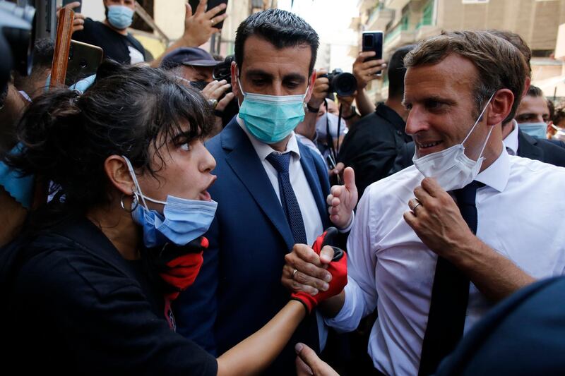 French President Emmanuel Macron listens to a resident as he visits a devastated street of Beirut. AP Photo