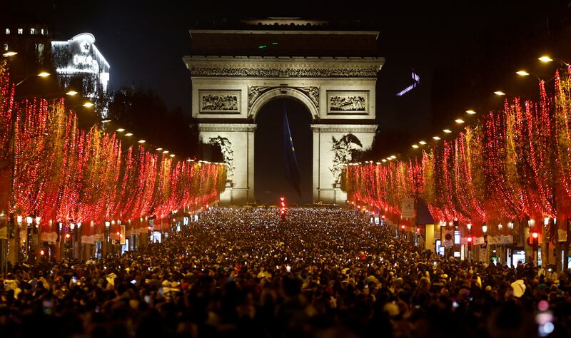 People attend New Year celebrations on the Champs-Elysees after a traditional light show and firework display were cancelled owing to the spread of the coronavirus. Reuters