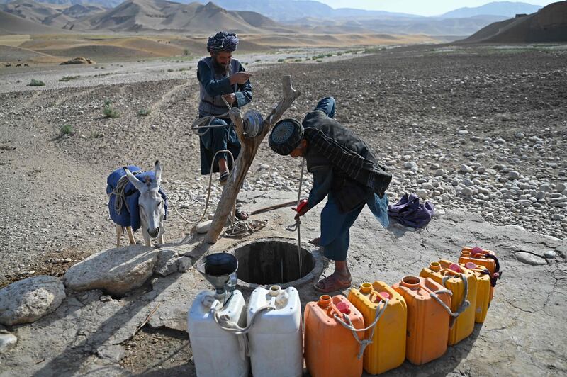 Men draw water from a well in Kandali village in the Afghan province of Balkh. AFP