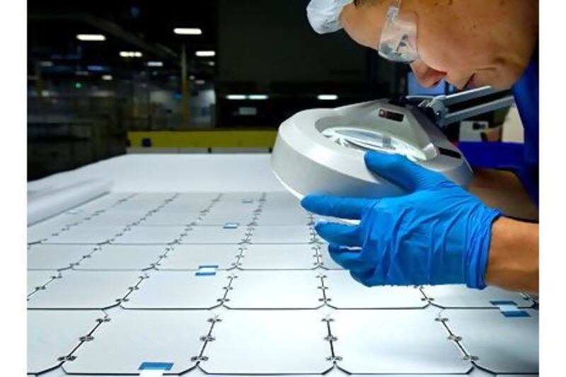 A SunPower employee checks panels in Milpitas, California. Warren Buffett bought two California SunPower projects for $2.5bn. David Paul Morris / Bloomberg News