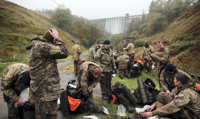 BRECON, WALES - OCTOBER 16:  British Army officer cadets from the Royal Military Academy Sandhurst, change their clothes as they take a break before begining a command task at a checkpoint as they take part in Exercise Long Reach in the Brecon Beacons on October 16, 2013 near Brecon, Wales. The 36-hour, 50-mile march with kit, involves 200 cadets, six weeks into junior term of their year-long course, being also made to conduct a number of command tasks, testing not only their physical endurance but also their mental ability when tired and under pressure. As a result, the exercise is seen as the officer cadets first major physical and mental hurdle of the Academys demanding training programme.  (Photo by Matt Cardy/Getty Images)