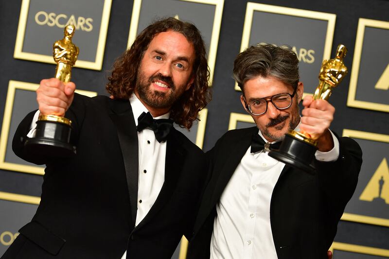 Spanish director and animator Alberto Mielgo, right, and Spanish producer Leo Sanchez show off their award for Best Animated Short Film for 'The Windshield Wiper' in the press room. AFP