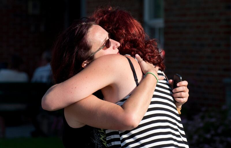 Federique Mailloux hugs a friend as they wait outside an emergency center for news of friends following a train derailment in downtown Lac Megantic, Quebec, that caused explosions of railway cars carrying crude oil on Saturday, July 6, 2013. (AP Photo/The Canadian Press, Paul Chiasson) *** Local Caption ***  Canada Oil Train Derailment.JPEG-0e4b1.jpg