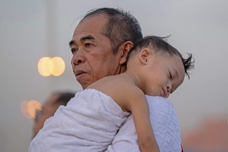 A pilgrim carrying his child on Mount Arafat on the second day of Hajj. AFP