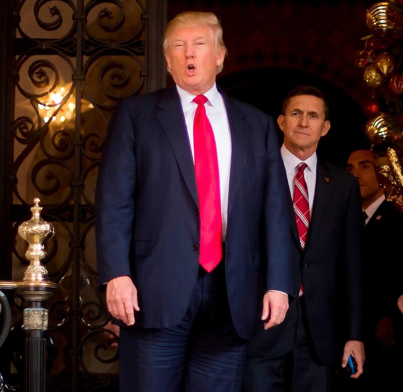 (FILES): This December 21, 2016 file photo shows US President-elect Donald Trump (L) with with Trump National Security Adviser designate Lt. General Michael Flynn (R) at Mar-a-Lago in Palm Beach, Florida.
Michael Flynn, Donald Trump's former national security advisor, has been charged with lying to investigators over his Russian contacts, becoming the seniormost official indicted in the probe into possible collusion between the Trump campaign and Moscow.
Flynn was charged November 30, 2017 with one count of lying about his private discussions with Sergey Kislyak, the Russian ambassador, regarding US sanctions being imposed on Moscow by the government of then president Barack Obama, a court document showed.
 / AFP PHOTO / JIM WATSON / XGTY